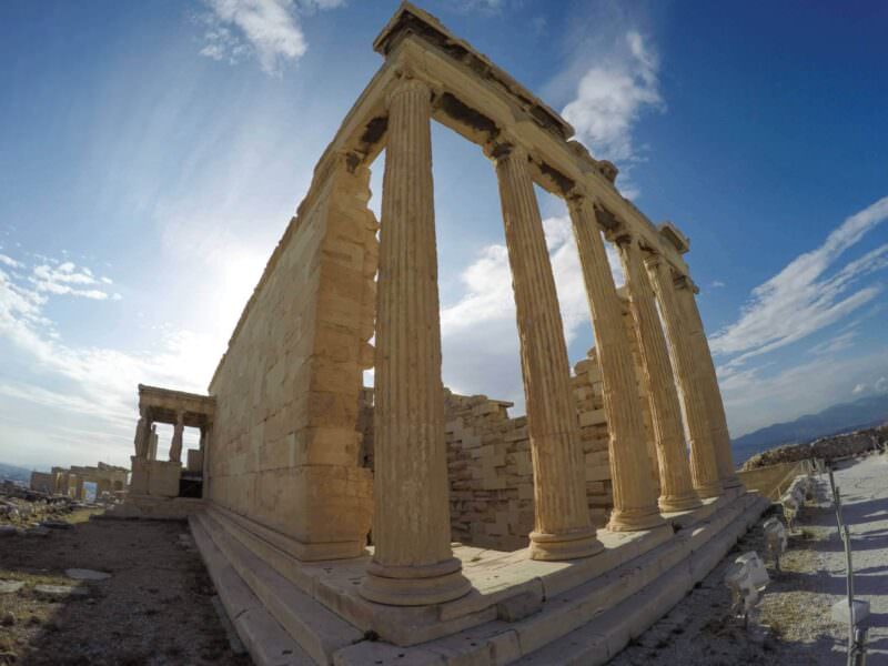 Fisheye shot of the Erechtheion's fluted columns on the Acropolis in Athens under a sunny sky