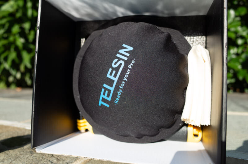 Telesin dome port's black fabric protective cover resting inside its packaging box