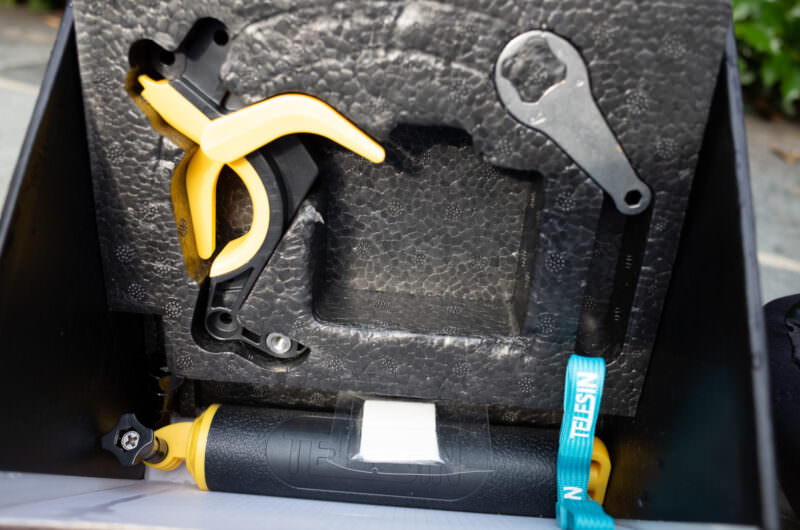 GoPro dome port handle and trigger mechanism laid out unassembled with mounting hardware