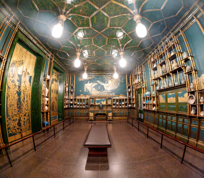 Freer Gallery's Peacock Room with gilded shelving, blue-green walls, and patterned ceiling