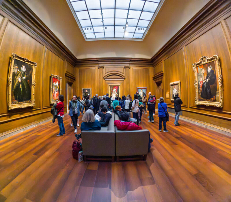 Museum gallery with gilded portrait paintings and visitors, shot on the GoPro HERO12 Black's wide fisheye lens