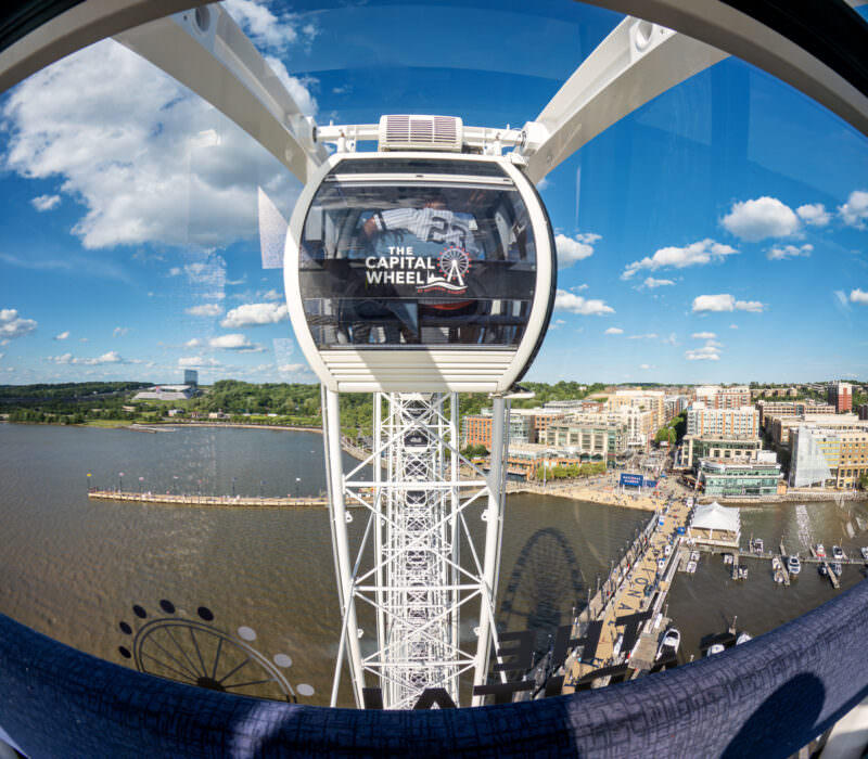Capital Wheel gondola cabin overlooking the National Harbor waterfront and Ferris wheel structure