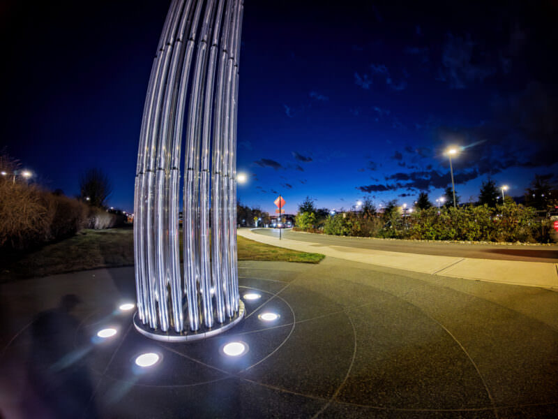 Night sample shot from the Insta360 Ace Pro 2 of a tall ribbed metal sculpture beside a roadway