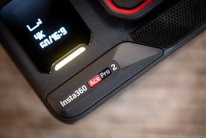 Close-up of the Insta360 Ace Pro 2 corner showing its logo badge, speaker mesh, and status screen