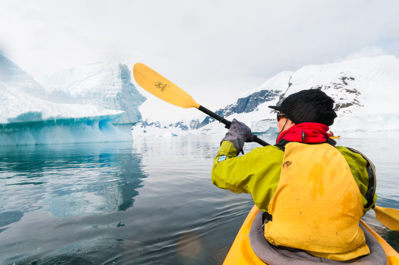 Point-of-view from tandem kayak gliding through icebergs at Cuverville Island, Antarctic Peninsula