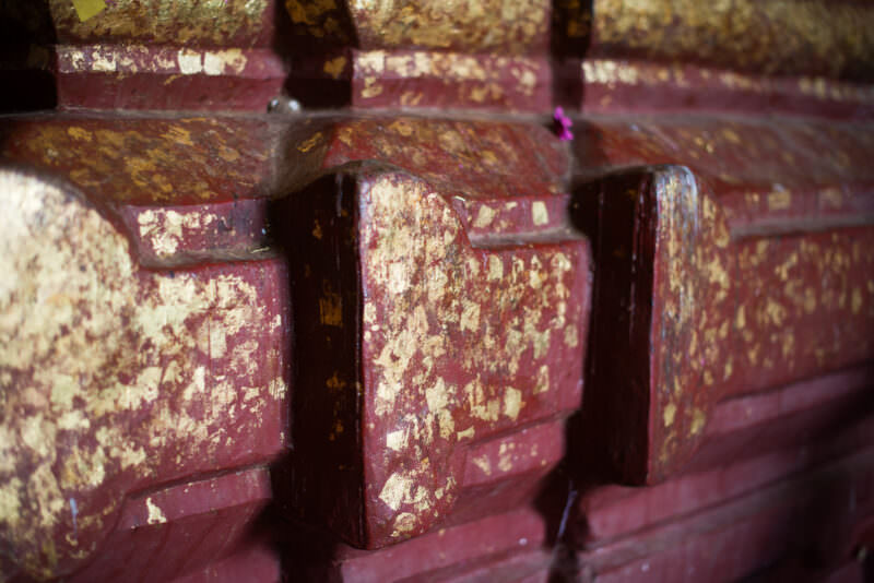 Red lacquered throne moldings at Dhammayangyi Temple densely encrusted with layers of gold leaf applied by worshippers