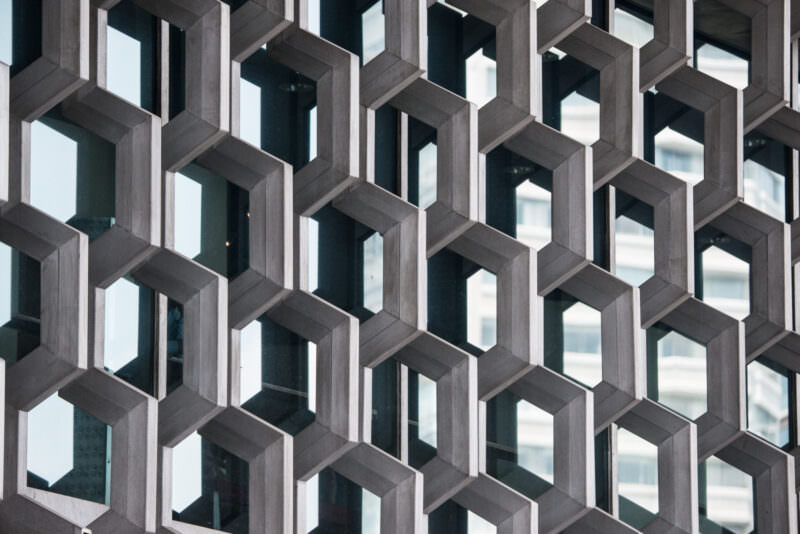 Close-up of hexagonal aluminum lattice screen on museum upper floor filtering daylight