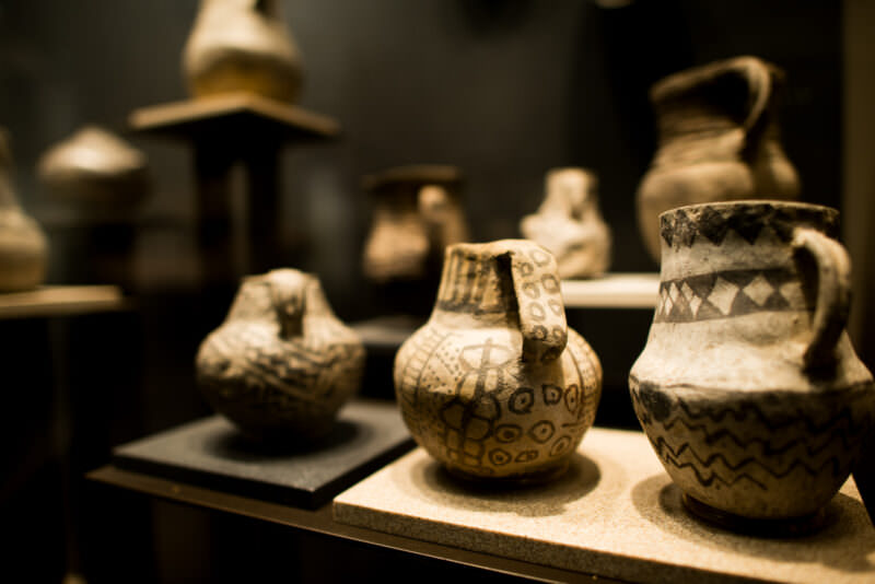 Display case of small pre-Columbian ceramic vessels, painted and incised with geometric patterns