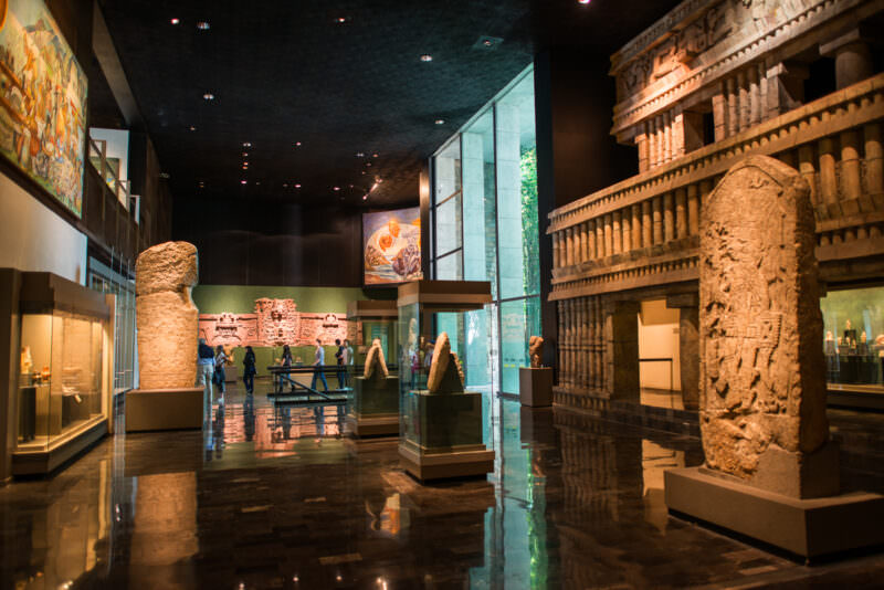 Sala Maya with free-standing stelae, reconstructed temple facade with Puuc colonnettes, large murals, and glass wall onto garden