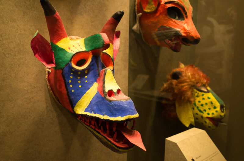 Brightly painted wood animal masks including horned devil and fox from ceremonial dance traditions