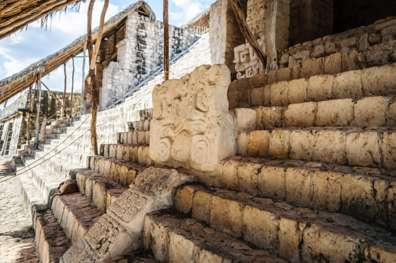 Stucco-decorated element resting on limestone steps below the six-level Acropolis at Ek' Balam