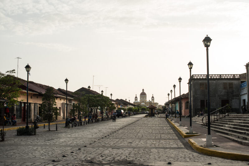 Cobblestone Calle La Calzada stretching toward the yellow dome of the Cathedral of the Assumption of Mary