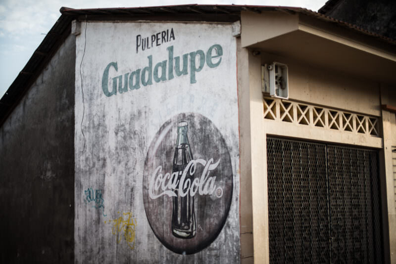 Weathered Coca-Cola advertisement painted on the wall of Pulperia Guadalupe along Calle La Calzada
