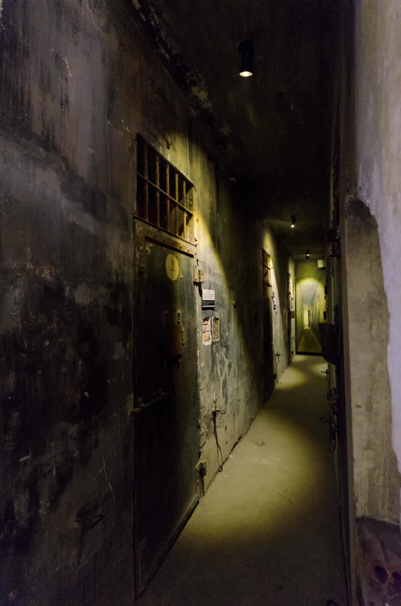 Barred iron doors lining the death row corridor inside Hoa Lo Prison