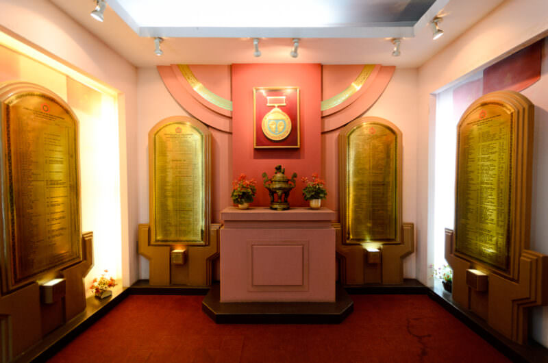 Golden memorial plaques and incense burner in a Hoa Lo Prison shrine room