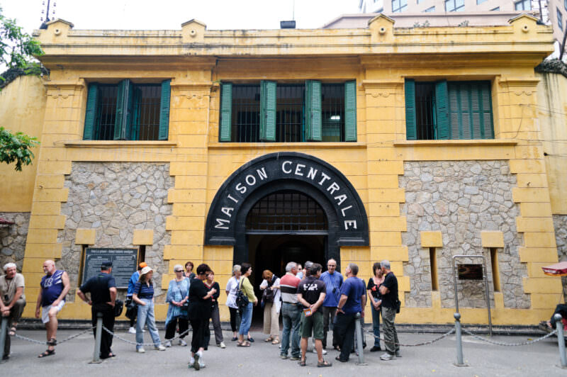 Tourists outside the Maison Centrale facade of Hoa Lo Prison Museum
