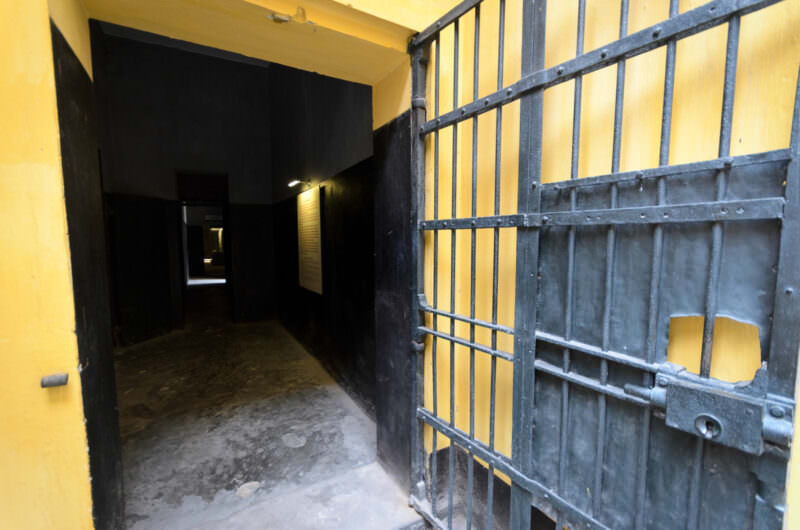 Open iron gate leading into a dim corridor inside Hoa Lo Prison