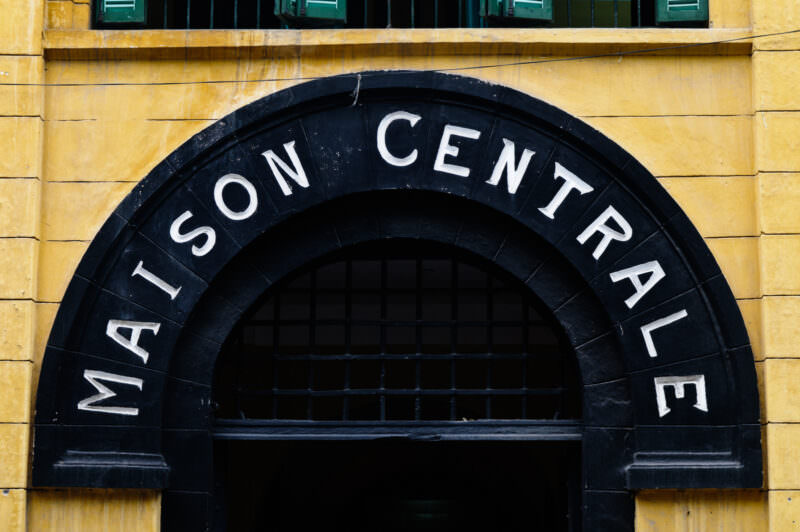 Arched Maison Centrale sign above the entrance to Hoa Lo Prison Museum