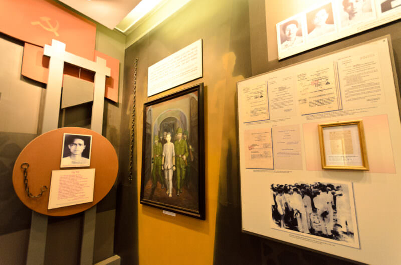 Paintings, colonial documents and chains displayed in a Hoa Lo Prison history exhibit