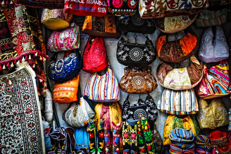 Embroidered bags, beaded purses and boots hanging on display at a Grand Bazaar textile stall