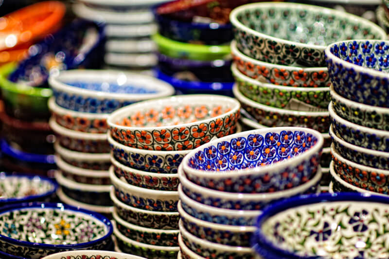 Stacks of hand-painted ceramic bowls in floral and geometric patterns at a Grand Bazaar pottery stall