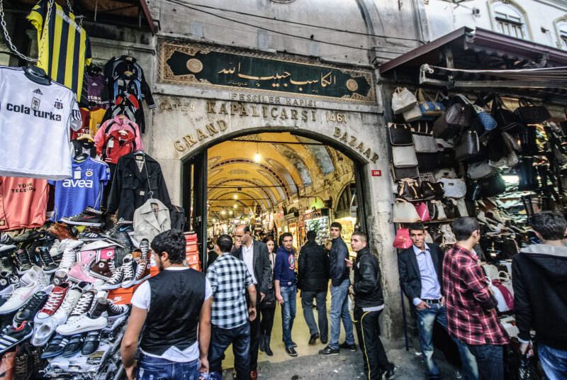 Fesçiler Kapısı gate entrance to the Grand Bazaar, its stone lintel inscribed 1461, flanked by shoe and bag stalls