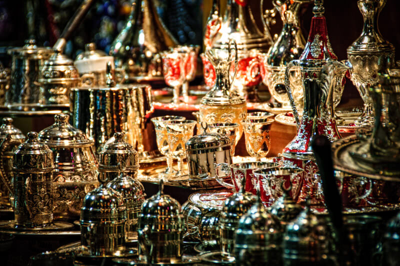 Ornate silver and enamel Turkish tea sets and glassware displayed in a Grand Bazaar metalwork shop