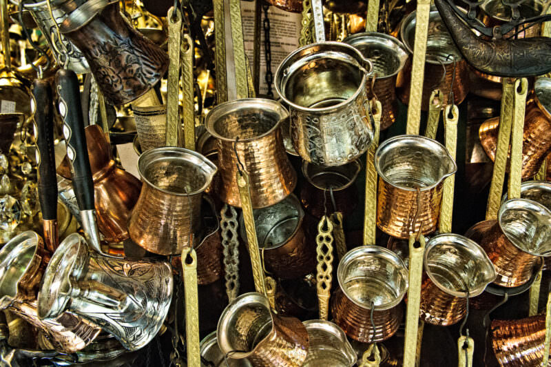 Rows of hammered copper and brass Turkish coffee cezves crowding a Grand Bazaar metalwork stall