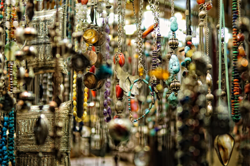Beaded necklaces and stone pendants hanging in rows at a Grand Bazaar jewelry stall