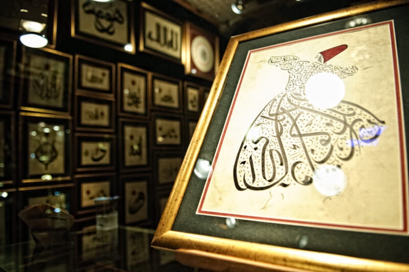 Framed Arabic calligraphy artwork depicting a Whirling Dervish displayed in a Grand Bazaar art shop
