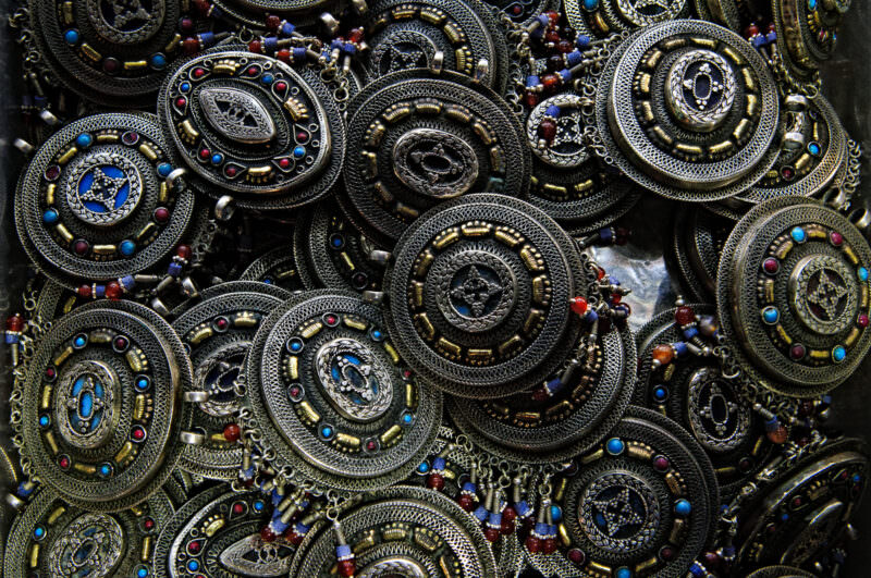 Ornate silver-toned pendants set with turquoise, carnelian and lapis beads piled at a Grand Bazaar jeweler