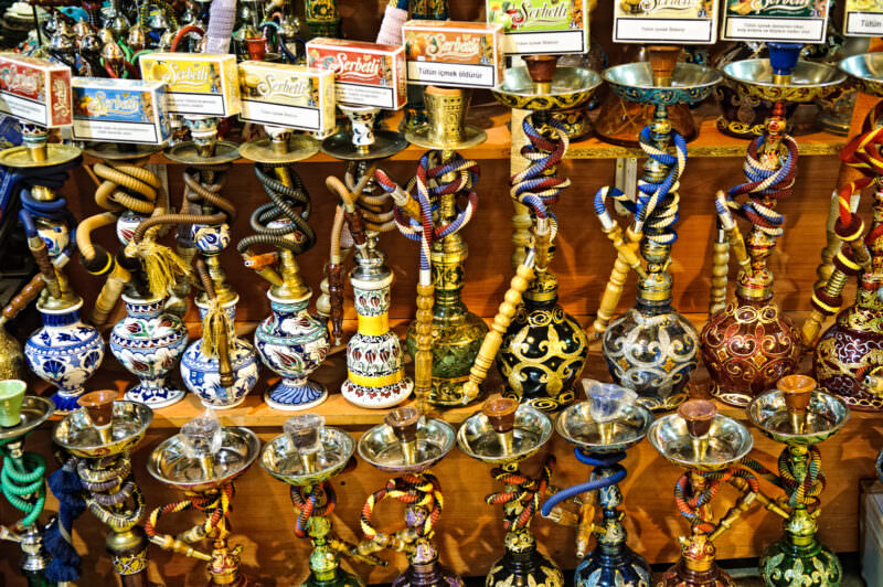 Rows of hand-painted ceramic narghile water pipes displayed on a shop shelf in the Grand Bazaar