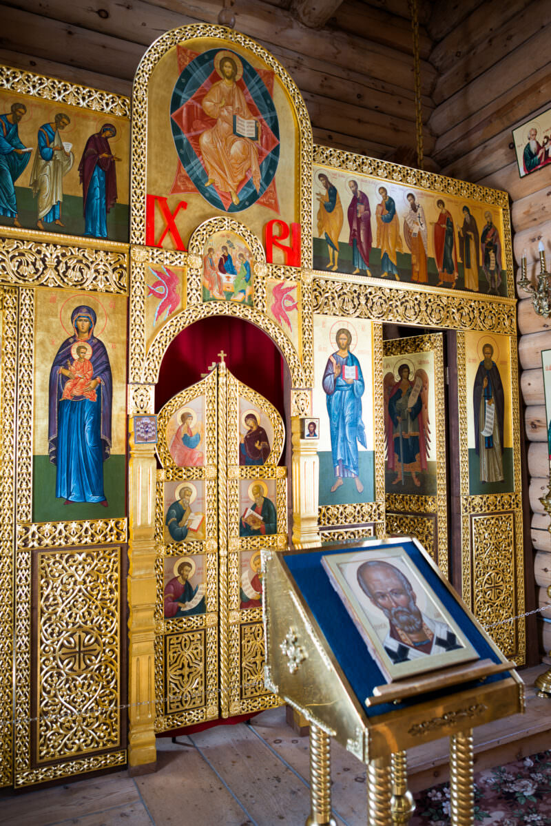 Ornate iconostasis with gilded tiers of painted icons filling the sanctuary of Trinity Church, King George Island