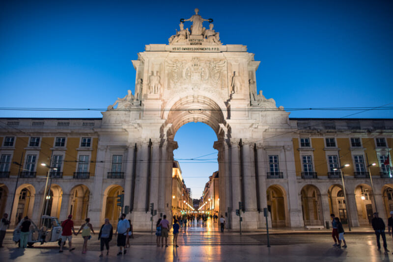 Arco da Rua Augusta lit at dusk framing the view down Rua Augusta in Lisbon's Baixa district