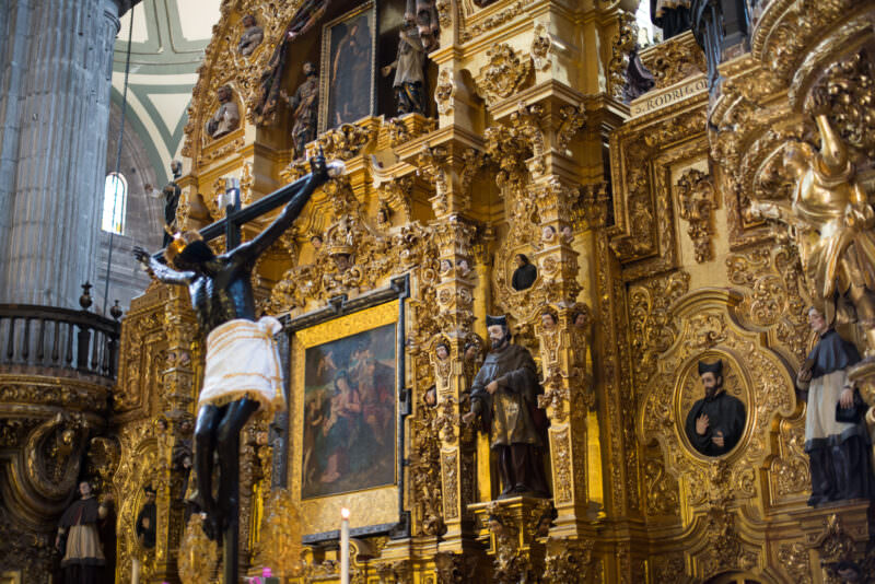 Altar del Perdón with darkened Cristo del Veneno crucifix before a gilded Churrigueresque retablo