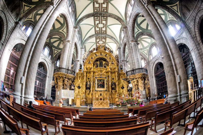 Altar del Perdón in fisheye view, gilded retablo beneath ribbed vaults flanked by monumental columns