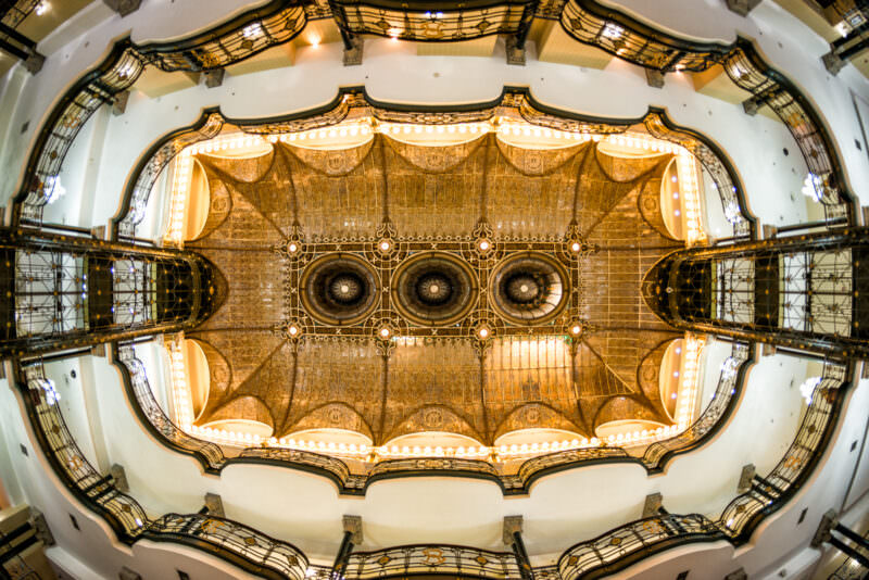 Mirrored view of Gran Hotel Ciudad de Mexico stained glass ceiling at night, creating a symmetrical kaleidoscope of amber and white light