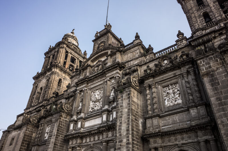 Catedral Metropolitana south facade rising from street level, layered Renaissance to Neoclassical stonework