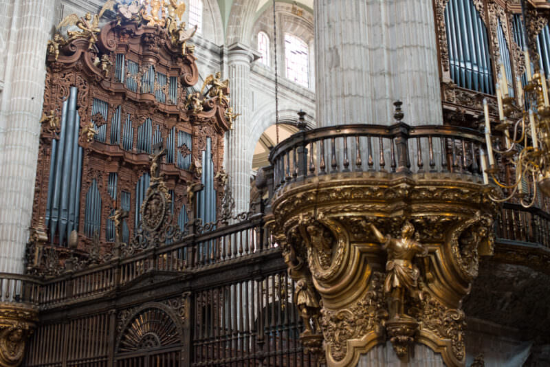 Both monumental Baroque pipe organs flanking the gilded pulpit in the cathedral choir