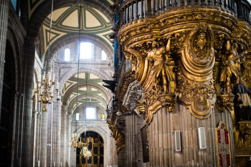 Gilded Baroque pulpit dominating the foreground, the barrel-vaulted nave receding behind it