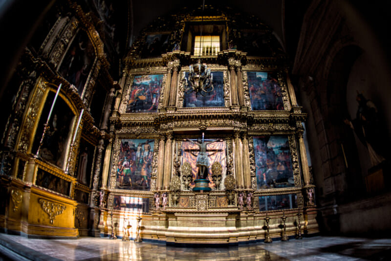 Gilded Baroque retablo of the Chapel of the Lord of the Column, central crucifix flanked by Passion-scene paintings