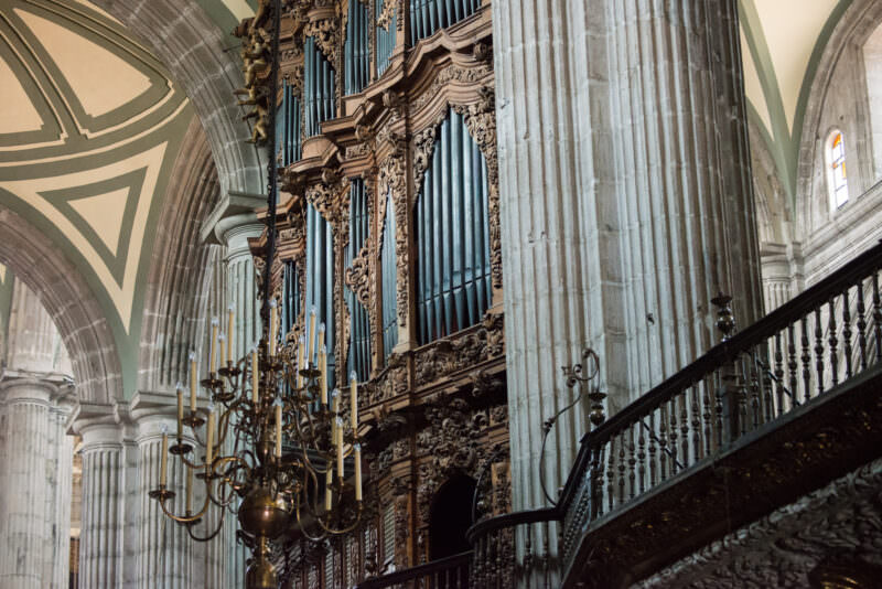 Monumental pipe organ rising beside a fluted column against the cathedral's ribbed vaults