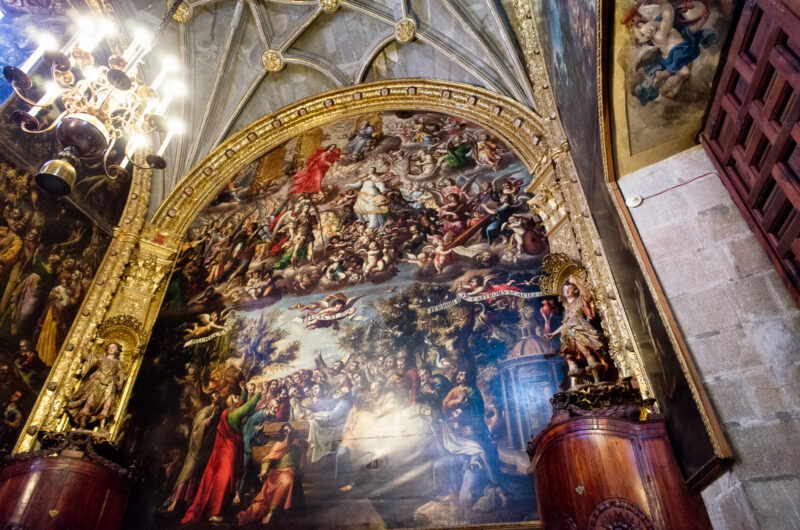 Monumental Baroque painting filling the sacristy's arched end wall beneath a Gothic ribbed vault