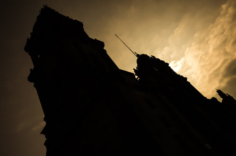 Catedral Metropolitana bell tower silhouetted against dramatic amber-lit storm clouds