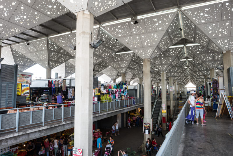 Mercado de Abasto Tirso de Molina's multi-level concourse under geometric perforated canopy casting dappled light on walkways