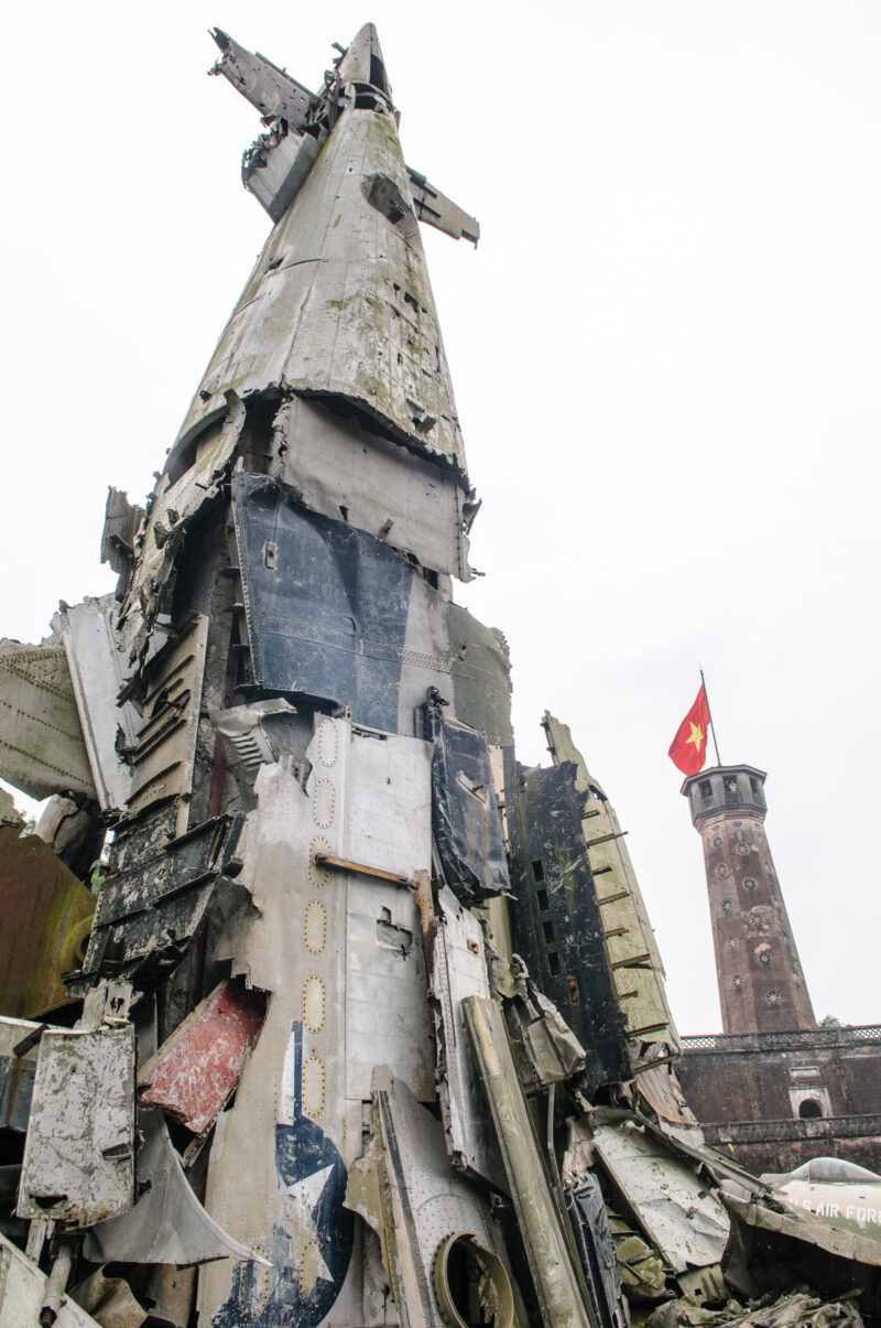 Torn B-52 Stratofortress fuselage wreckage rising as a monument beside the Hanoi Flag Tower