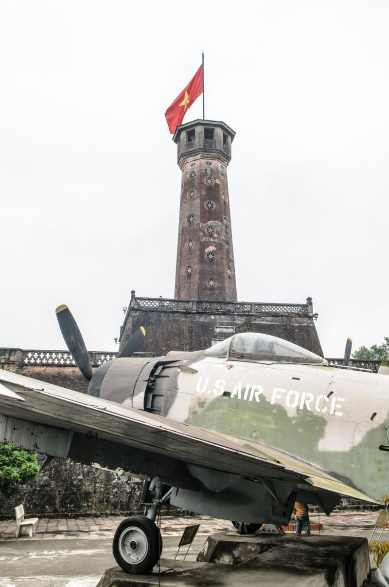 A U.S. Air Force A-1 Skyraider parked before the brick Hanoi Flag Tower at the Vietnam Military History Museum