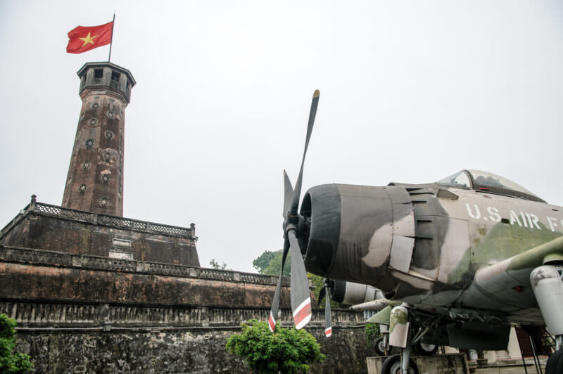 Propeller and camouflaged nose of a Douglas A-1 Skyraider beside the Hanoi Flag Tower