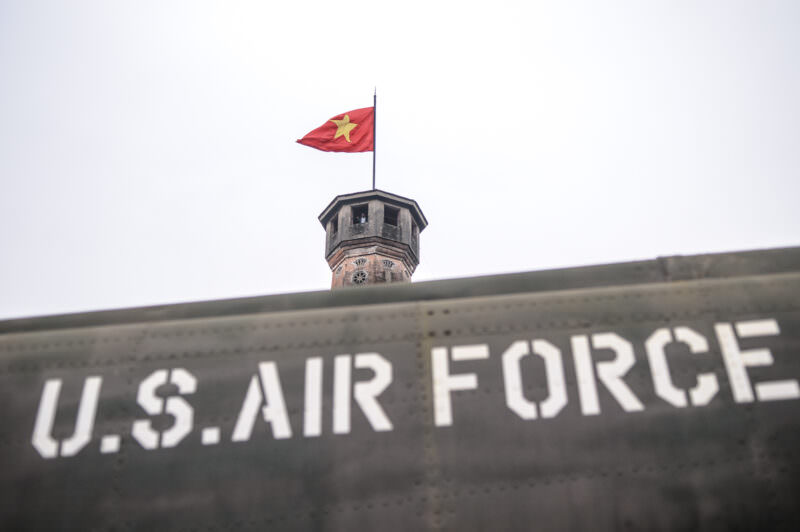 Captured U.S. Air Force aircraft fuselage displayed at the base of the brick Hanoi Flag Tower