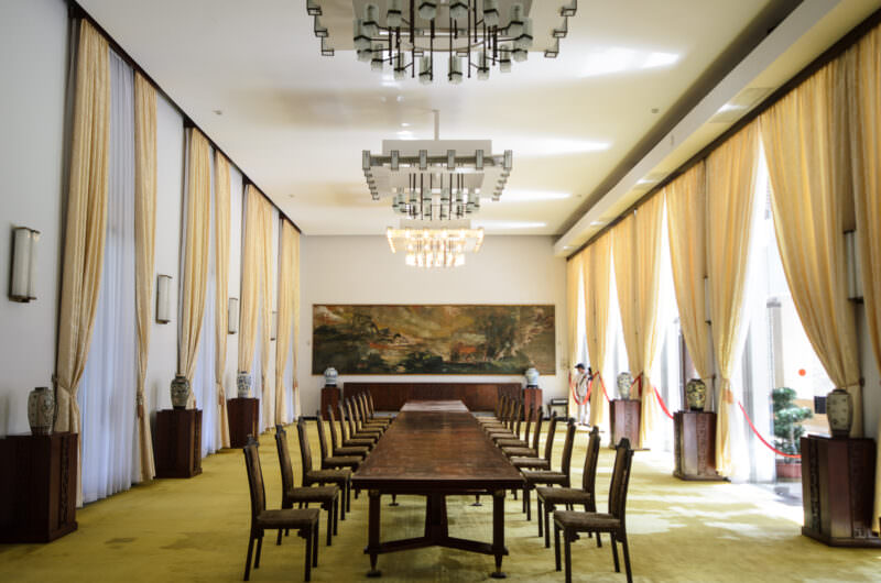 Long banquet table and tiered glass chandeliers in Reunification Palace's symmetrical Banquet Chamber
